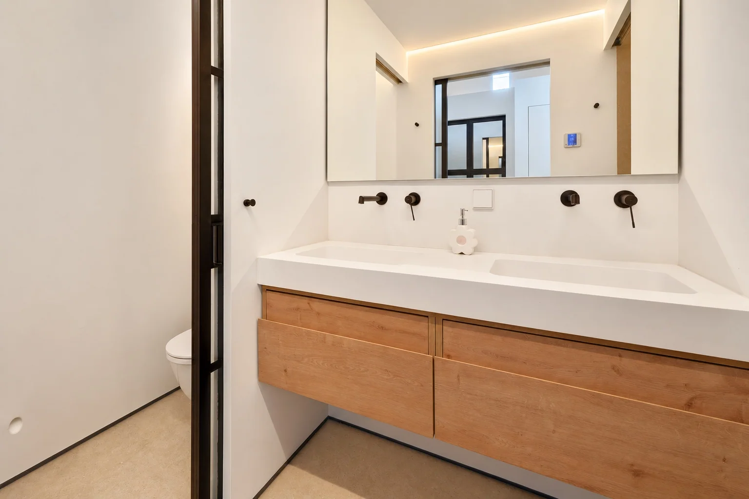 Baño con doble lavabo, mueble de madera y grifería negra