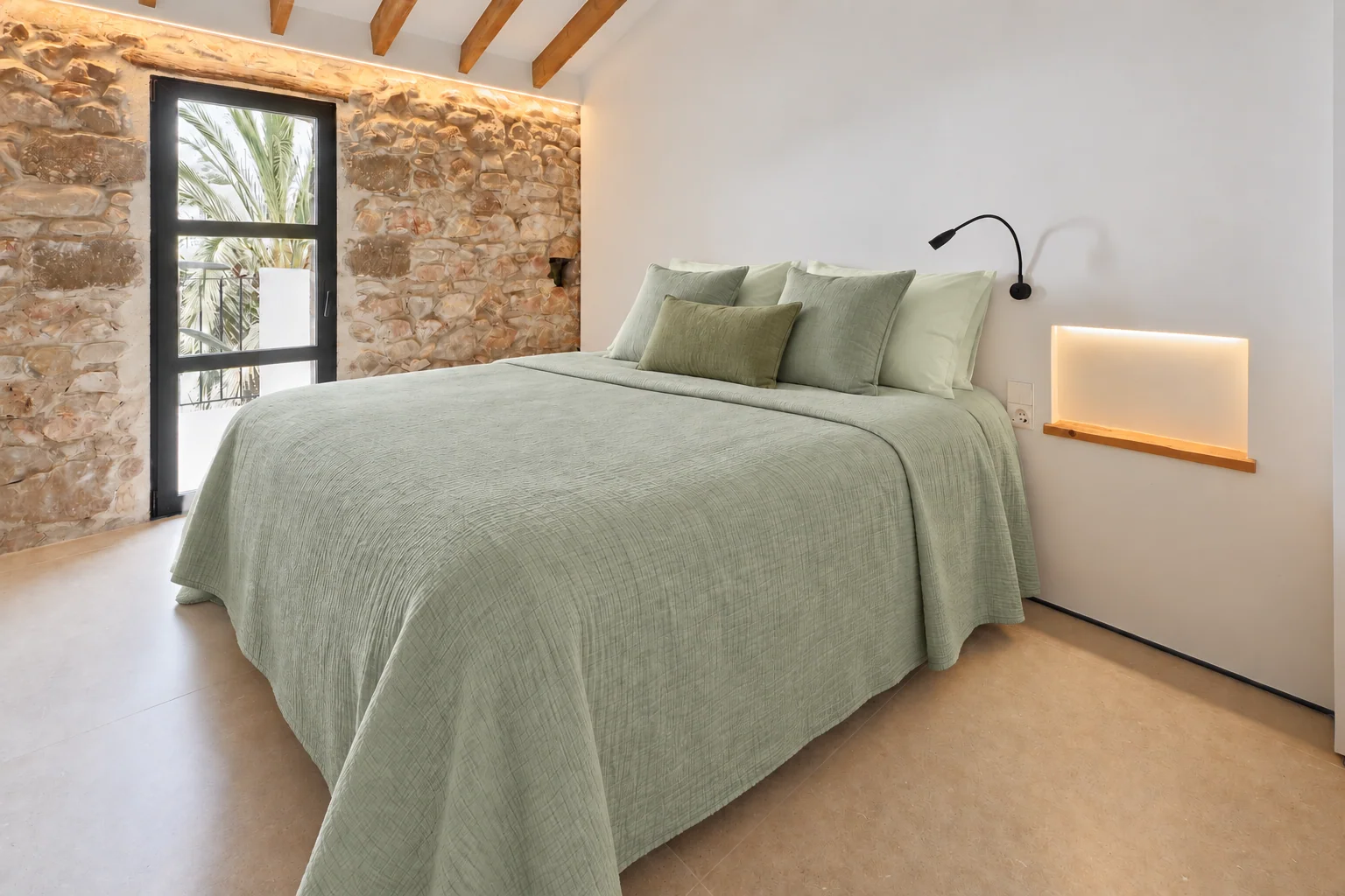 Dormitorio con textiles verdes y apliques junto a la cama