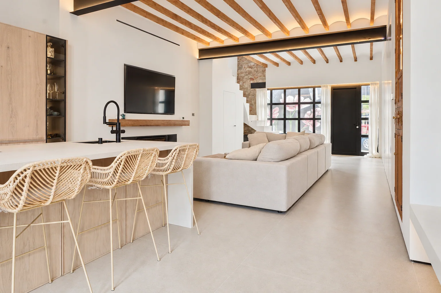 Cocina y salón unidos bajo un techo de vigas de madera